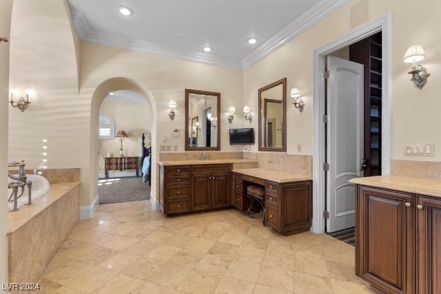 bathroom with ornamental molding, vanity, and a relaxing tiled tub