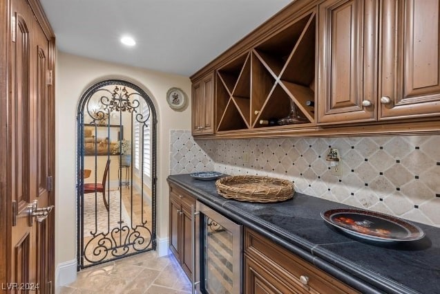 kitchen with backsplash, dark stone countertops, and wine cooler