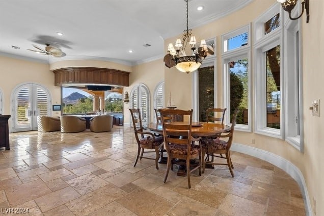 dining space with ceiling fan with notable chandelier and ornamental molding