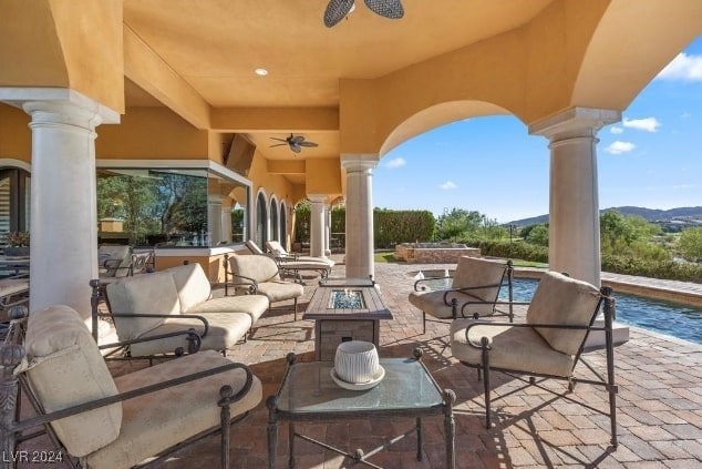 view of patio featuring ceiling fan and a fire pit