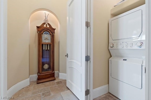 clothes washing area featuring stacked washer and dryer