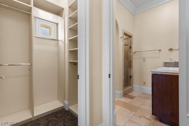 bathroom featuring vanity, ornamental molding, and a shower with door