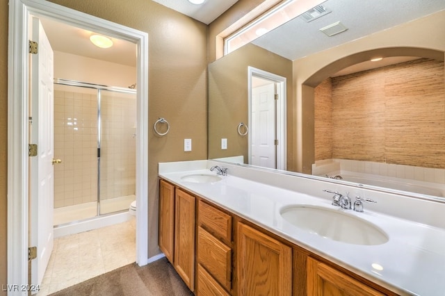 bathroom featuring vanity, a textured ceiling, a shower with shower door, tile patterned floors, and toilet