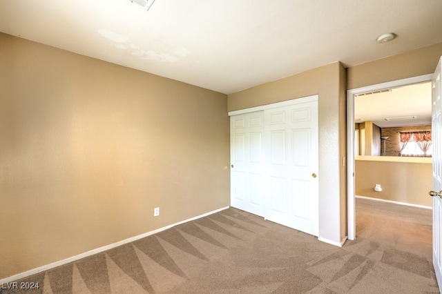 unfurnished bedroom with a closet and carpet flooring