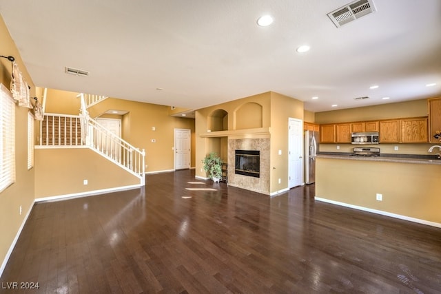 unfurnished living room with a fireplace, dark hardwood / wood-style flooring, and sink