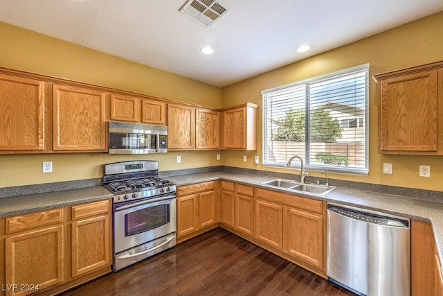 kitchen featuring appliances with stainless steel finishes, sink, and dark hardwood / wood-style flooring