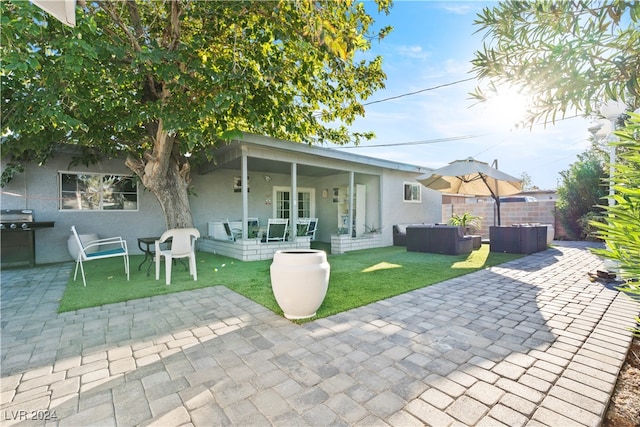 rear view of house with a yard and a patio