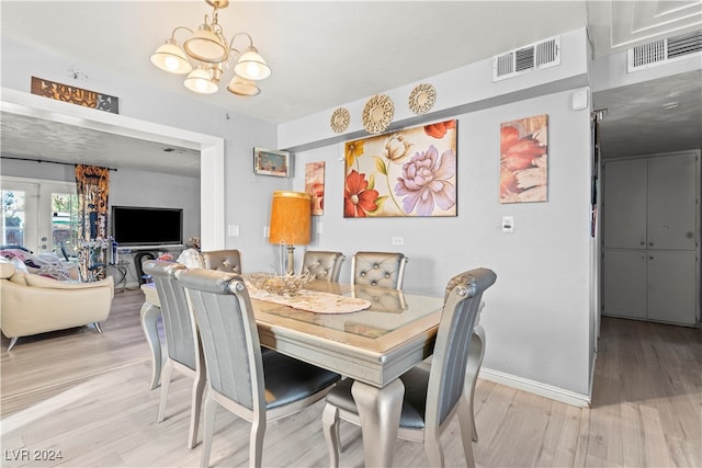 dining room featuring light hardwood / wood-style floors and an inviting chandelier