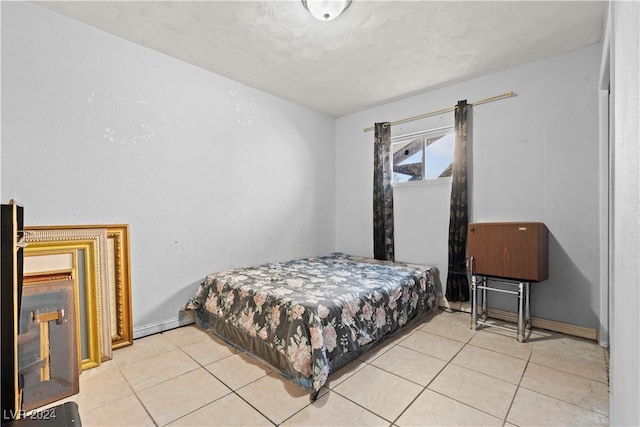 bedroom with a textured ceiling and light tile patterned floors