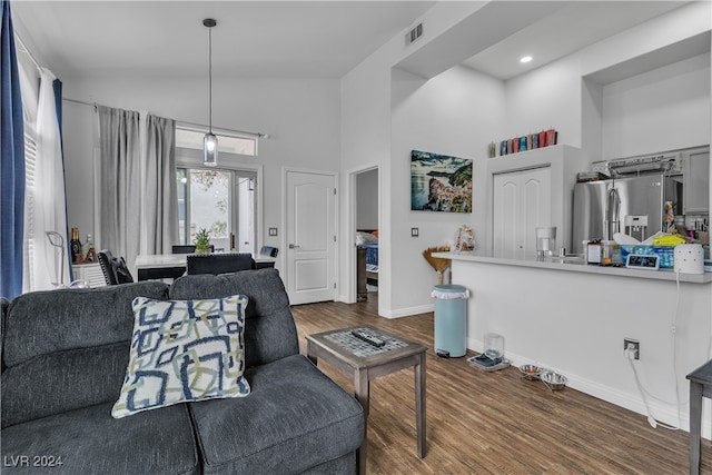 living room featuring high vaulted ceiling and wood-type flooring