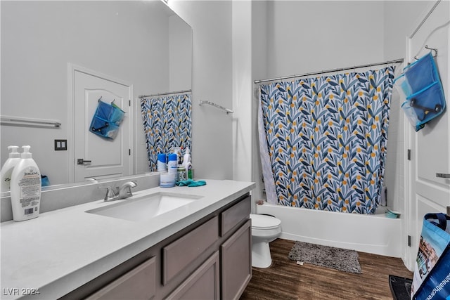 full bathroom with shower / tub combo with curtain, hardwood / wood-style flooring, vanity, and toilet