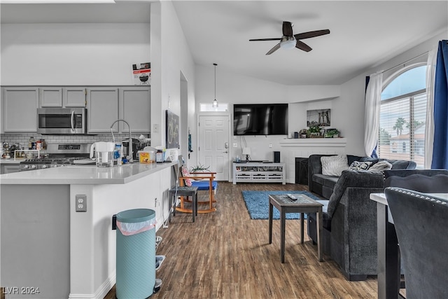 living room with lofted ceiling, ceiling fan, and dark wood-type flooring