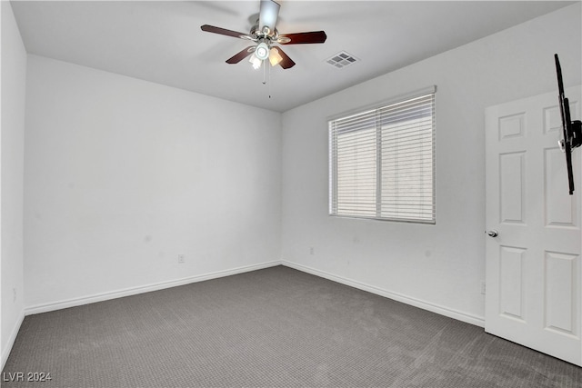 empty room with dark colored carpet and ceiling fan