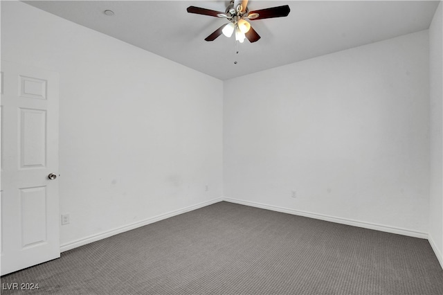 spare room with ceiling fan and dark colored carpet