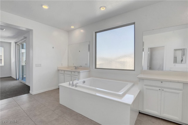 bathroom with vanity, a tub, and tile patterned floors