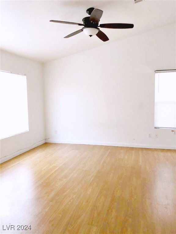 unfurnished room with a wealth of natural light, ceiling fan, and light hardwood / wood-style floors