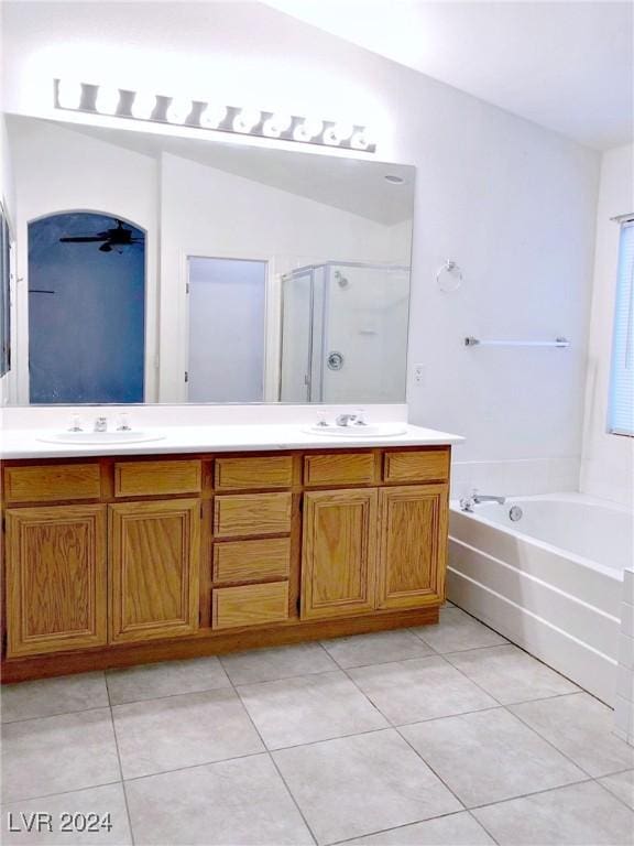 bathroom featuring tile patterned flooring, shower with separate bathtub, vanity, and vaulted ceiling