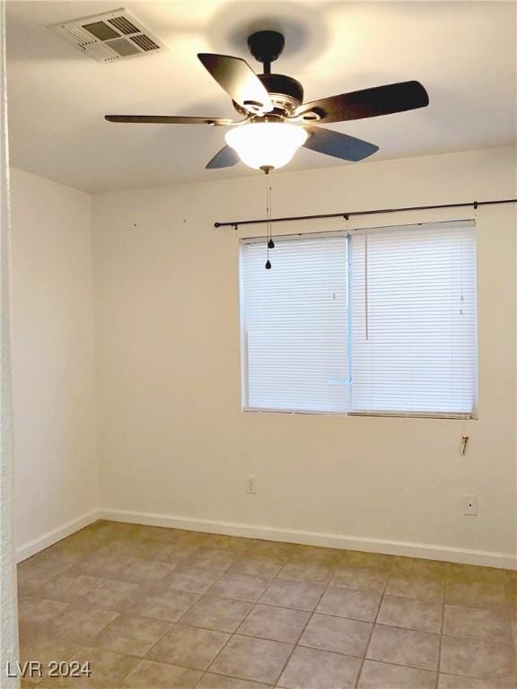 tiled spare room with ceiling fan