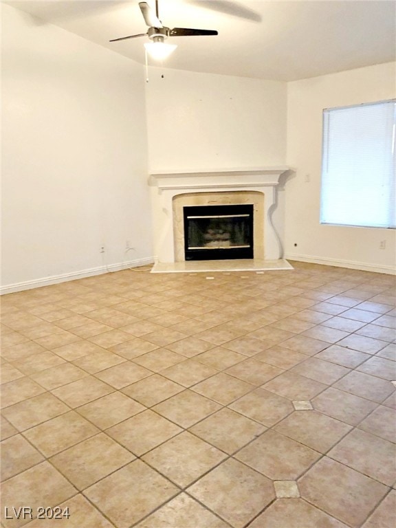 unfurnished living room featuring ceiling fan and a fireplace