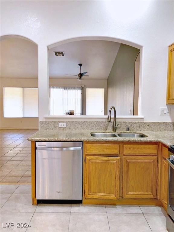 kitchen with ceiling fan, sink, stainless steel appliances, vaulted ceiling, and light tile patterned flooring