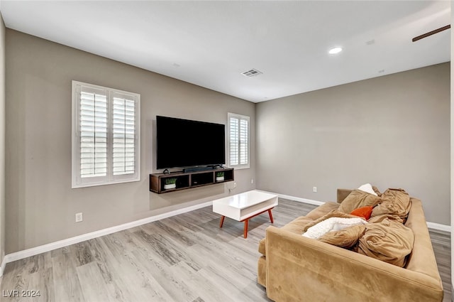 living room featuring wood-type flooring, ceiling fan, and plenty of natural light