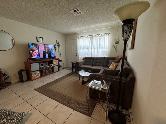 living room featuring light tile patterned flooring and a textured ceiling