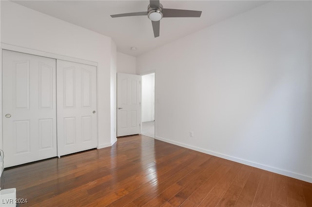 unfurnished bedroom featuring ceiling fan, a closet, and dark hardwood / wood-style flooring