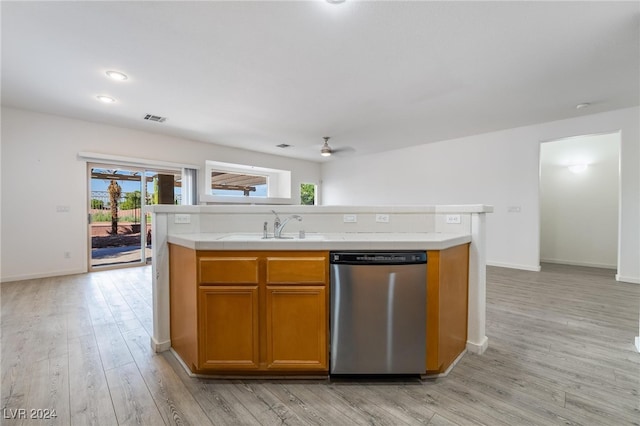 kitchen with an island with sink, dishwasher, light wood-type flooring, ceiling fan, and sink