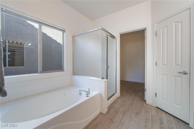 bathroom with independent shower and bath and hardwood / wood-style floors