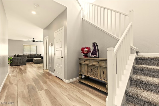 stairway featuring vaulted ceiling, ceiling fan, and hardwood / wood-style flooring