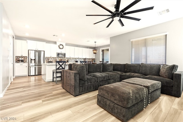 living room with ceiling fan and light hardwood / wood-style floors