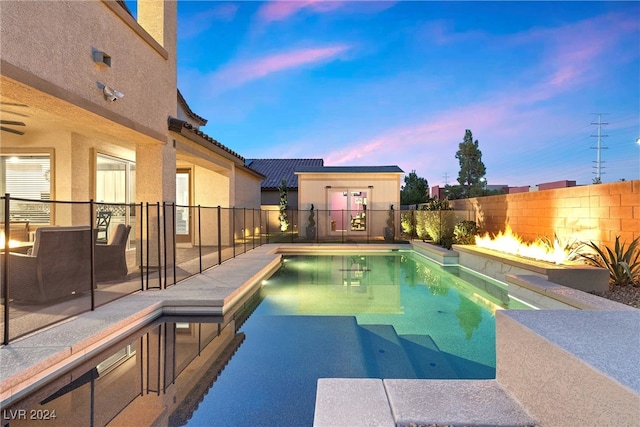 pool at dusk with a patio area