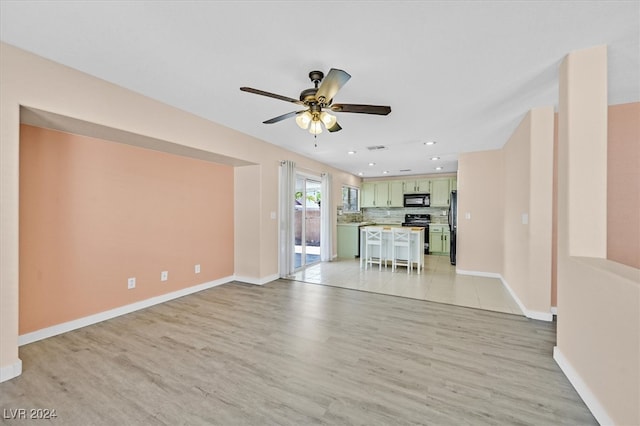 unfurnished living room featuring ceiling fan and light hardwood / wood-style flooring