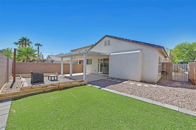 rear view of property featuring a patio and a yard