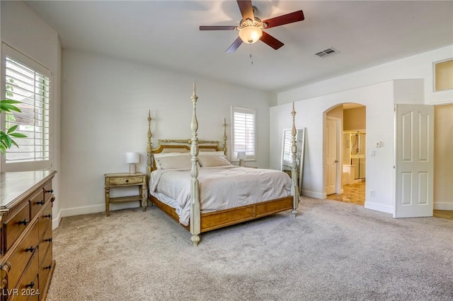 carpeted bedroom featuring ceiling fan and ensuite bath