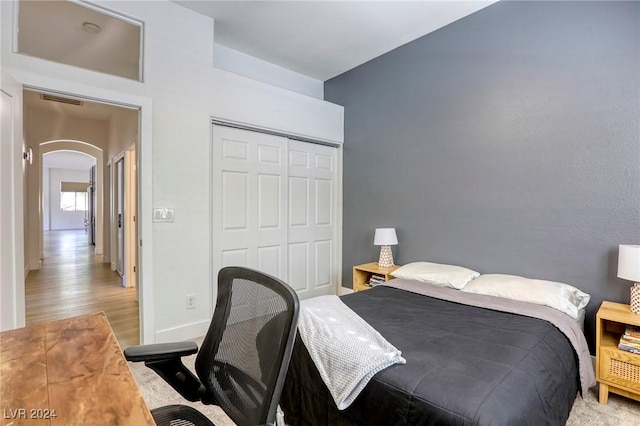 bedroom with light hardwood / wood-style flooring and a closet