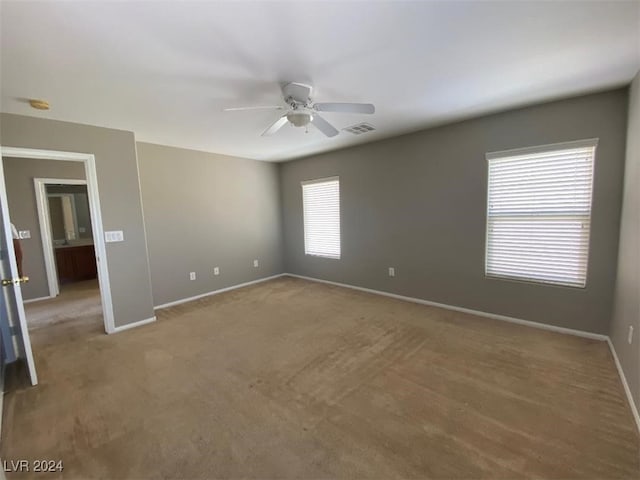 carpeted spare room with ceiling fan and a wealth of natural light