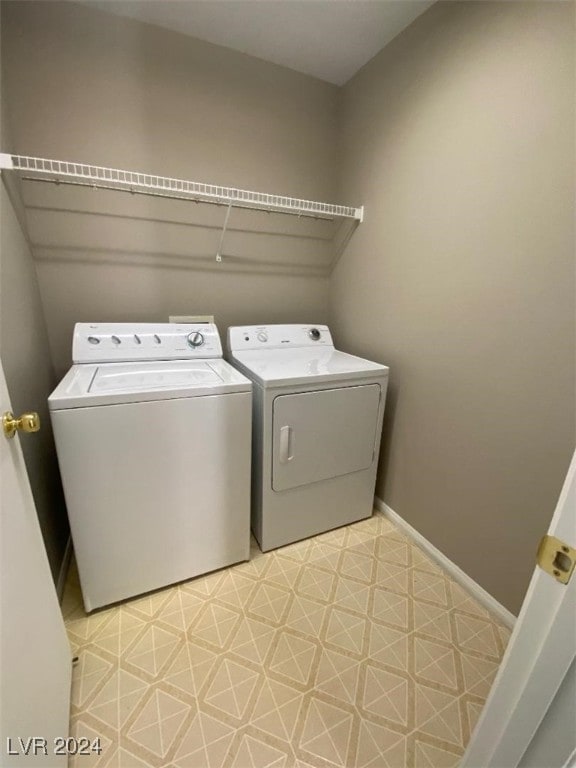 laundry area with light tile patterned floors and washer and dryer