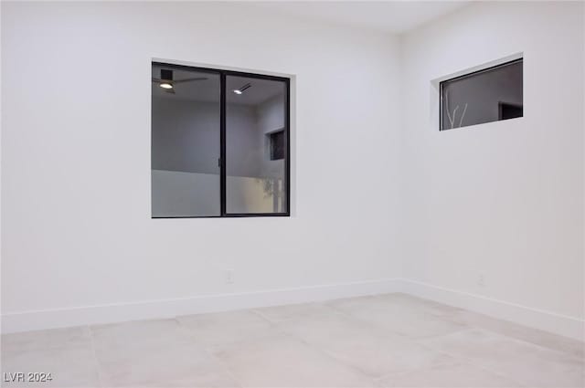 spare room featuring baseboards and light tile patterned floors