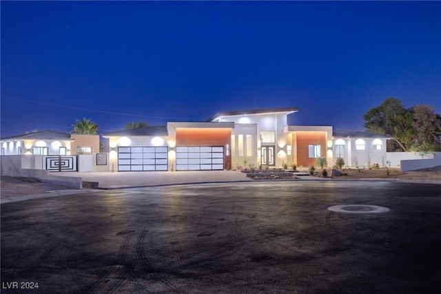 contemporary home featuring driveway, an attached garage, and stucco siding