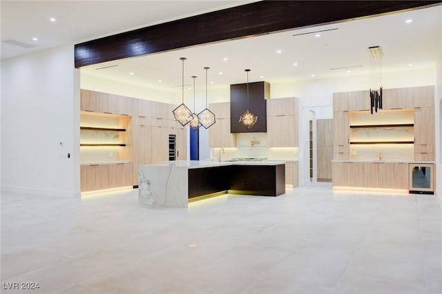 kitchen featuring light brown cabinetry, a large island with sink, open shelves, and modern cabinets