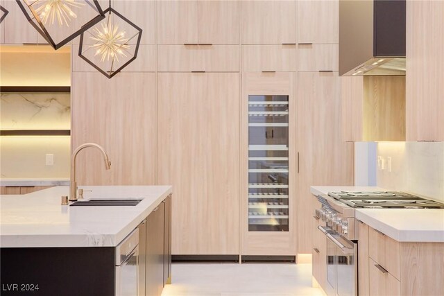 kitchen with stainless steel stove, light countertops, light brown cabinetry, a sink, and modern cabinets