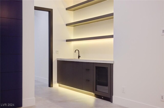 bar featuring baseboards and a sink