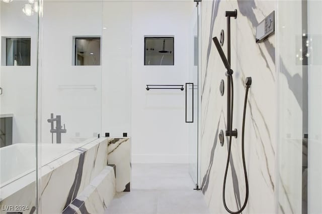 bathroom featuring a marble finish shower