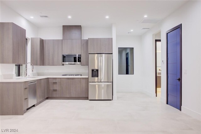 kitchen featuring light countertops, appliances with stainless steel finishes, modern cabinets, and visible vents