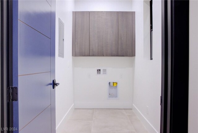 washroom featuring washer hookup, cabinet space, baseboards, and light tile patterned flooring