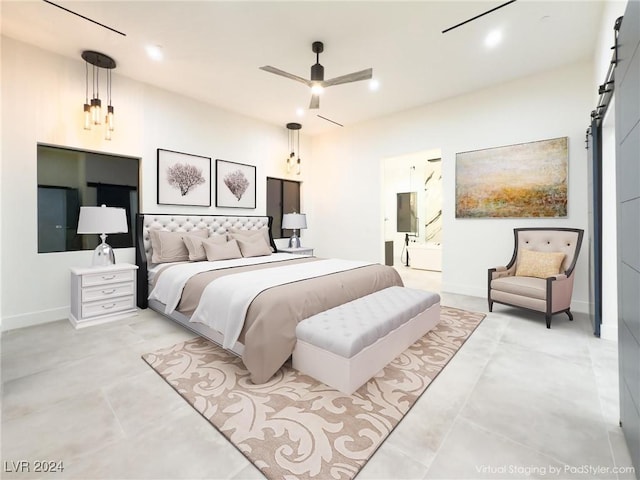 bedroom with a ceiling fan, baseboards, ensuite bath, and a barn door