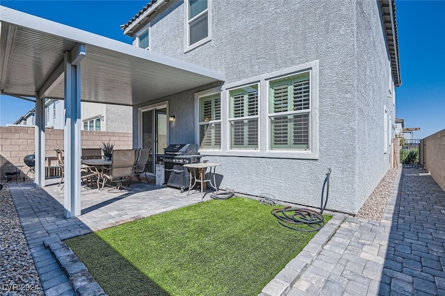 rear view of house with a yard and a patio area