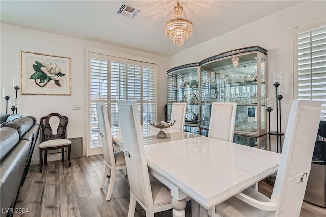 dining area with a notable chandelier and light wood-type flooring