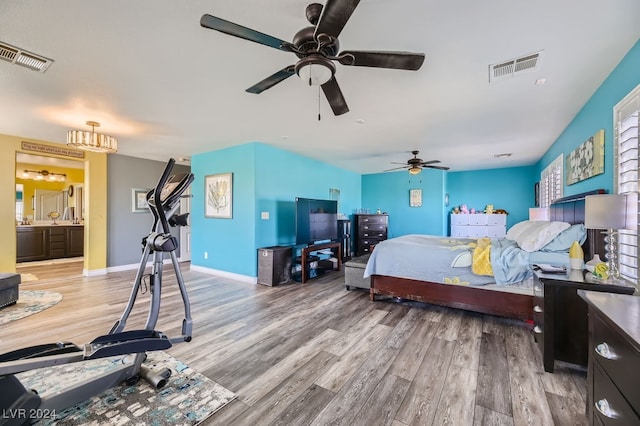 bedroom with hardwood / wood-style floors, ensuite bathroom, and ceiling fan